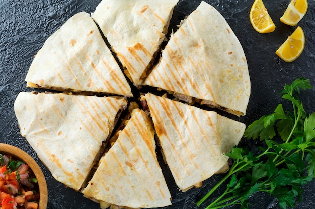 Quesadilla messicana con pollo, mais, fagioli rossi, formaggio e peperoni e salsa. Messa a fuoco selettiva Vista dall'alto.