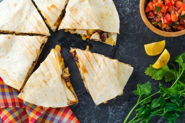 Quesadilla messicana con pollo, mais, fagioli rossi, formaggio e peperoni e salsa. Messa a fuoco selettiva Vista dall'alto.