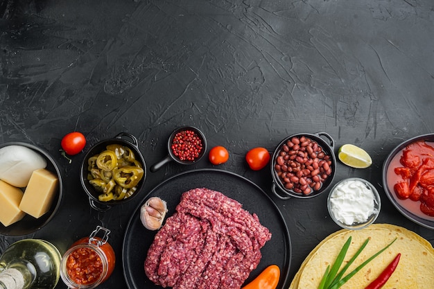 Quesadilla messicana e ingredienti, su sfondo nero, vista dall'alto laici piatta