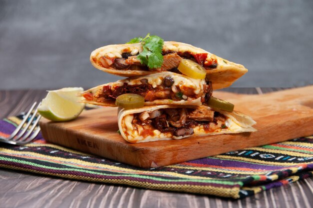 Quesadillas di pollo isolati su tavola di legno e vista laterale stuoia del fastfood su fondo di legno