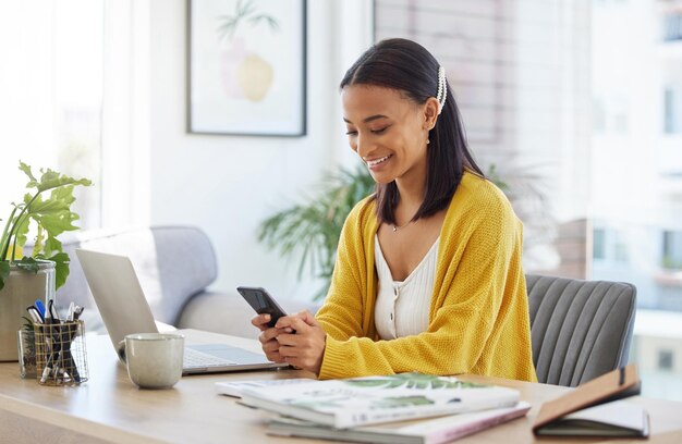 Questa è una buona notizia. Inquadratura di una giovane donna d'affari che utilizza un telefono in un ufficio moderno al lavoro.