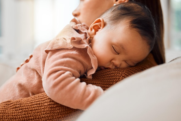 Questa piccola adora il pisolino. Inquadratura di un'adorabile bambina che dorme sulle braccia di sua madre