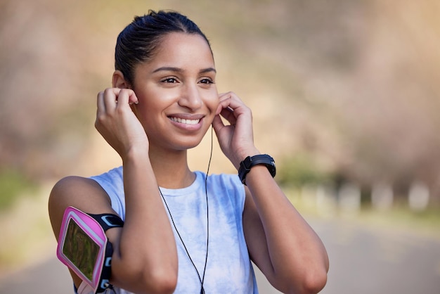 Questa traccia mi mette sempre dell'umore giusto. Inquadratura ritagliata di una giovane atleta femminile attraente che ascolta la musica mentre è fuori per una corsa.