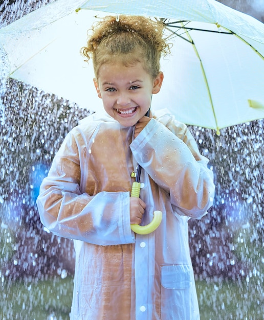 Questo è così eccitante Inquadratura di una bambina giocosamente in piedi sotto la pioggia con in mano l'ombrello