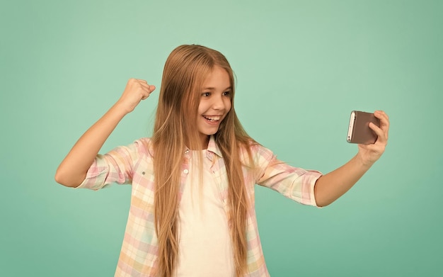 Questo è semplicemente incredibile Guardare video su un dispositivo mobile Piccola ragazza che usa un telefono cellulare Piccola bambina con uno smartphone Adorabile bambino che impara nuove tecnologie Carino utente della tecnologia del telefono cellulare