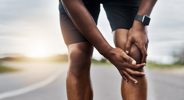 Questo non sembra giusto Colpo del primo piano di un uomo sportivo che soffre di dolore al ginocchio mentre si esercita all'aperto