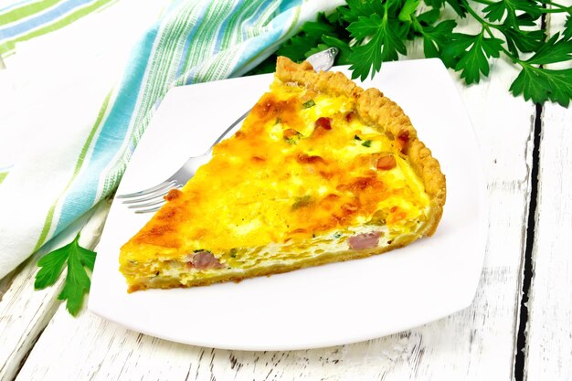 Quiche con zucca e pancetta nel piatto su lavagna luminosa