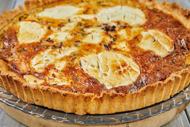 Quiche di formaggio di capra su sfondo di legno Cucina gourmet francese