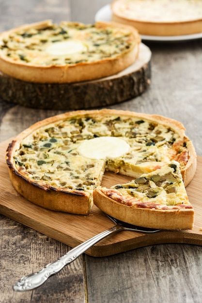 Quiche francese Lorraine con le verdure su una tavola di legno rustica