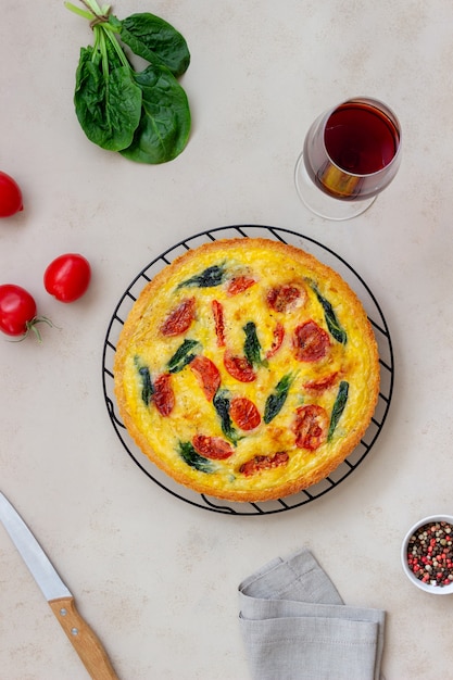 Quiche o torta con pomodori, spinaci e formaggio. Mangiare sano. Cibo vegetariano. Cucina francese.