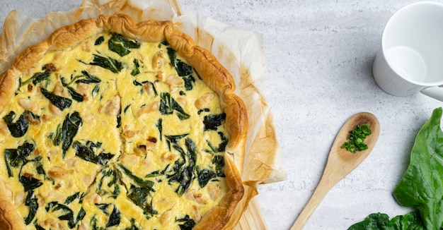 Quiche ripiene di pollo, bietola con cucchiaio di legno sul tavolo morbido