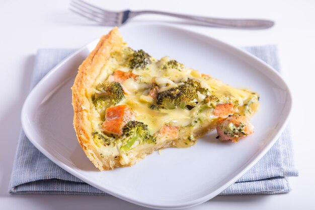 Quiche (torta aperta) con trota, broccoli e formaggio. Dolci fatti in casa non zuccherati, torta tradizionale. Avvicinamento.