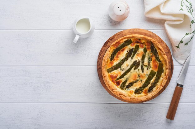 Quiche Torta di asparagi fatta in casa o quiche con formaggio e spinaci su sfondo bianco del tavolo in legno Quiche francese tradizionale Vista dall'alto