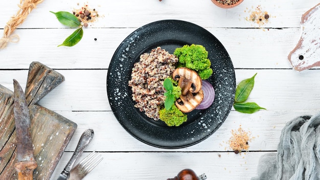 Quinoa con funghi e verdure su un piatto Vista dall'alto Spazio libero per il testo