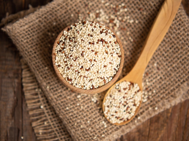 Quinoa cruda mista in ciotole su fondo di legno Cibo sano e senza glutine