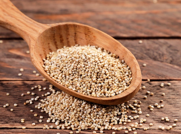 Quinoa in un primo piano del cucchiaio di legno su un fondo di legno