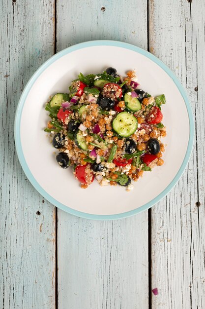 Quinoa insalata vegetariana, pomodori, cetrioli, ceci, olive, erbe aromatiche, ricotta