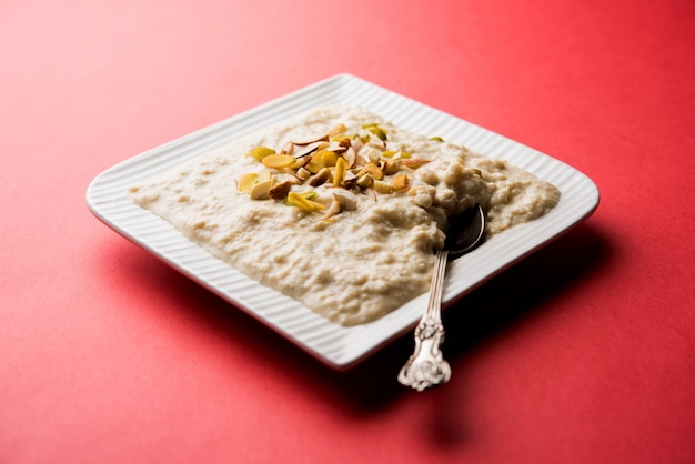 Rabdi dolce o Lachha Rabri o basundi, fatto con latte puro guarnito con frutta secca. Servito in una ciotola su sfondo lunatico. Messa a fuoco selettiva