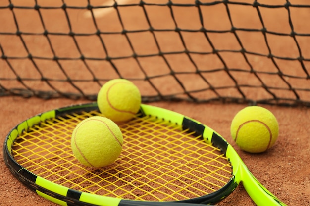 Racchetta da tennis con palline da tennis su campo in terra battuta