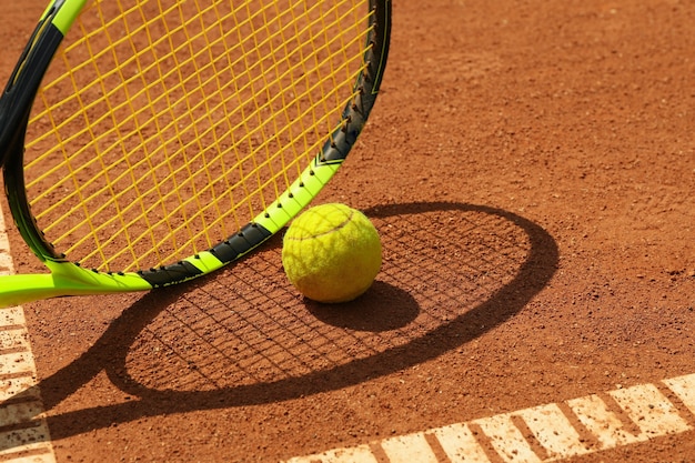 Racchetta da tennis e pallina da tennis su campo in terra battuta