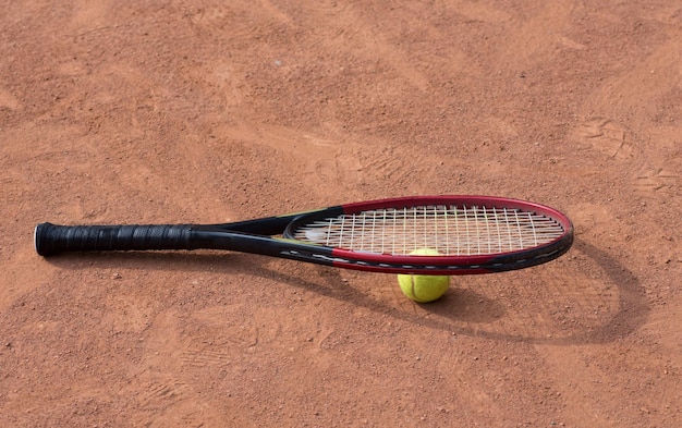 Racchetta da tennis e palline sul campo in terra battuta