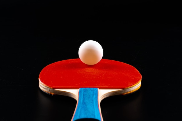 Racchetta di ping-pong rossa su fondo scuro. Attrezzatura sportiva