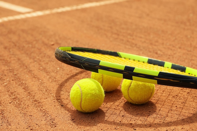 Racchetta e palline da tennis su campo in terra battuta