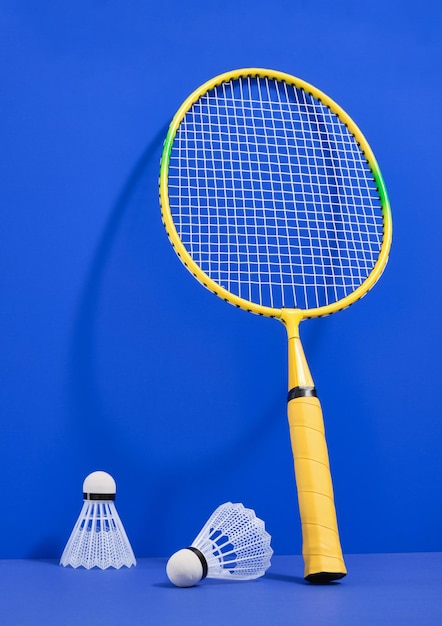 Racchetta luminosa per giocare a badminton Shuttlecocks bianchi su uno sfondo blu Idea di sport