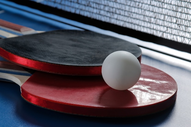 Racchette da ping pong con una palla sul tavolo