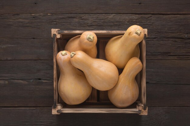 Raccogli le zucche su un tavolo di legno in una scatola, vista dall'alto