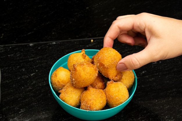 raccogliendo a mano il "bolinho de chuva", una ricetta tradizionale brasiliana a base di pasta fritta