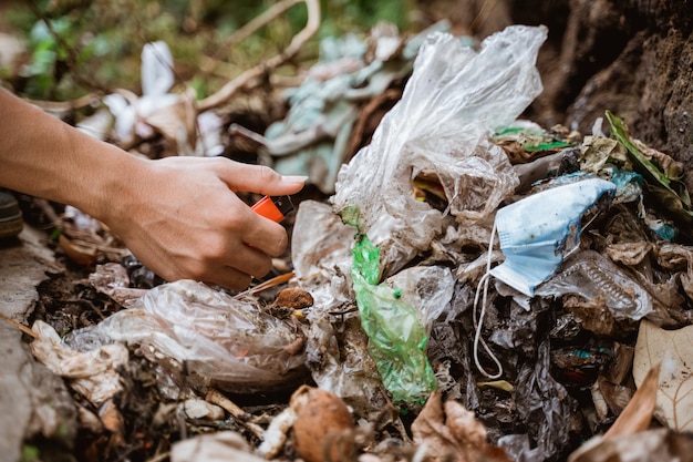 Raccogliere a mano i rifiuti di plastica e metterli nel sacco della spazzatura