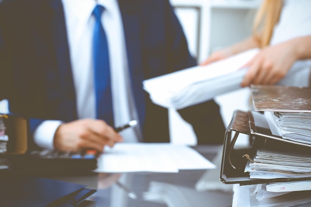Raccoglitori con documenti in attesa di essere elaborati con uomo d'affari o contabile di nuovo sfocato. Bilancio di pianificazione contabile. Audit, assicurazione e concetto di business