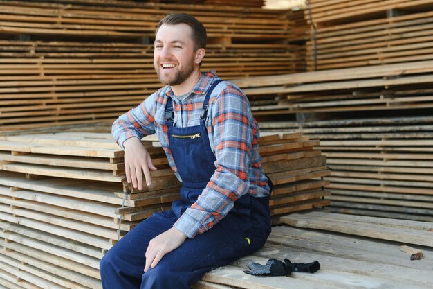Raccolta del legname per la costruzione Falegname impila tavole Sfondo industriale Flusso di lavoro autentico