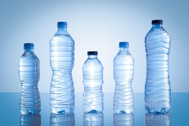 Raccolta di diverse bottiglie d'acqua in plastica isolate su sfondo blu