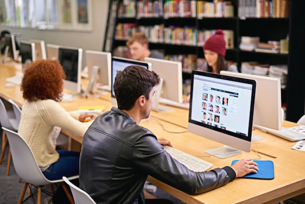 Raccolta di informazioni per il suo progetto di ricerca Inquadratura di studenti che lavorano al computer in una biblioteca universitaria