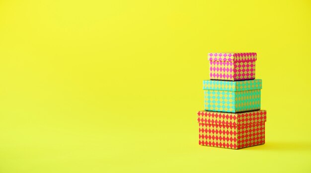 Raccolta di scatole regalo colorate su sfondo giallo. Banner. Regali per la festa di compleanno. Natale e anno nuovo concetto