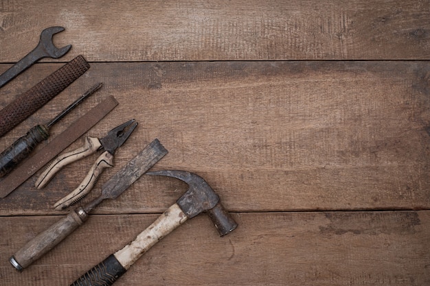 Raccolta di vecchi utensili manuali per la lavorazione del legno su un banco di lavoro grezzo in legno con spazio di copia