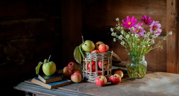 Raccolta fresca delle mele mature e sane dell'azienda agricola in un barattolo di vetro, in un canestro.