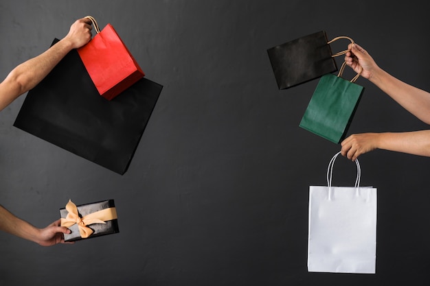 Raccolto di mano che tiene la borsa della spesa o la borsa dei regali per lo shopping o lo sfondo dello shopping online