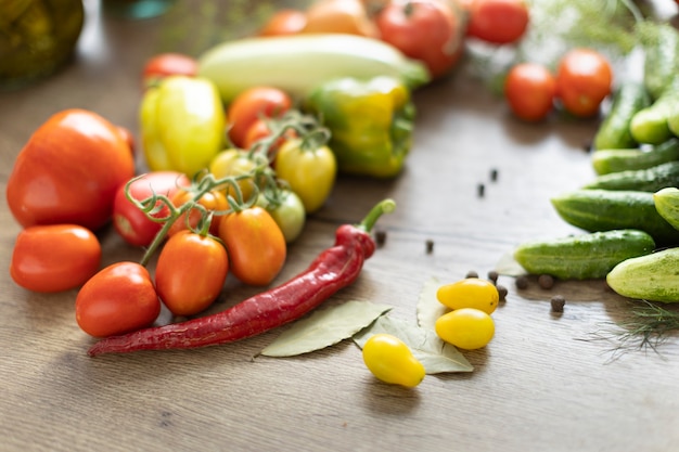 Raccolto di verdure sul tavolo, pomodori, cetrioli, peperoni.