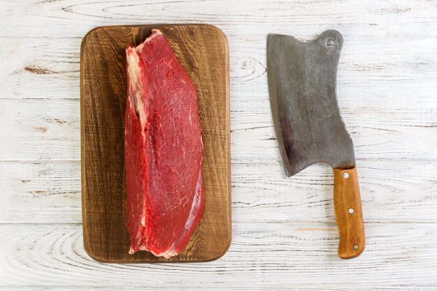 Raccordo di vitello di manzo crudo fresco rosso sul tagliere. fondo in legno bianco