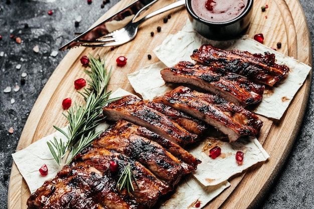 Rack piccante di costolette di ricambio con salsa barbecue servita su tagliere di legno Menu del ristorante ricetta del libro di cucina dietetico vista dall'alto