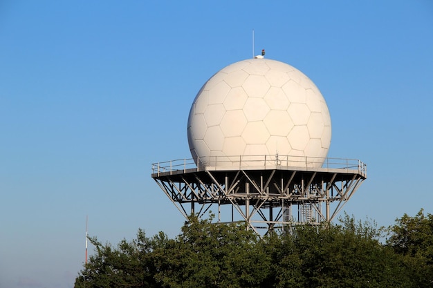 Radar sferico bianco per i satelliti che ricevono su una struttura metallica isolata sopra il cielo blu