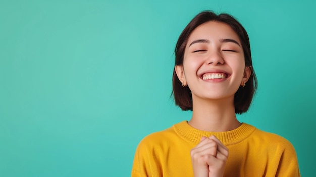 Radiante gioia giovane donna adulta del sud-est asiatico che esprime la felicità isolata su uno sfondo solido con ampio spazio per la copia