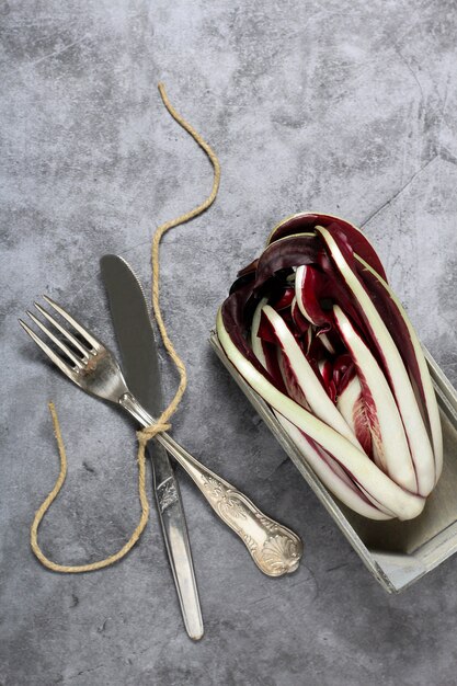 Radicchio rosso all'interno di una scatola di legno, con posate sul lato sinistro