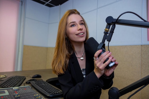 Radio. Ragazza bionda carina con microfono presso lo studio radiofonico