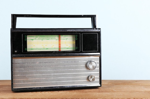 Radio retrò sul tavolo di legno su sfondo colorato chiaro