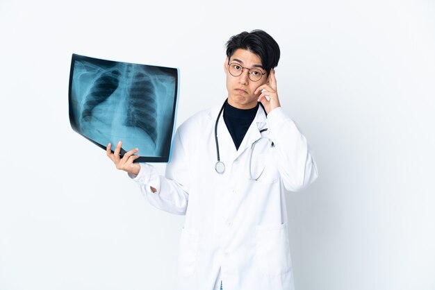 Radiografia della holding dell'uomo del giovane medico isolata che pensa un'idea