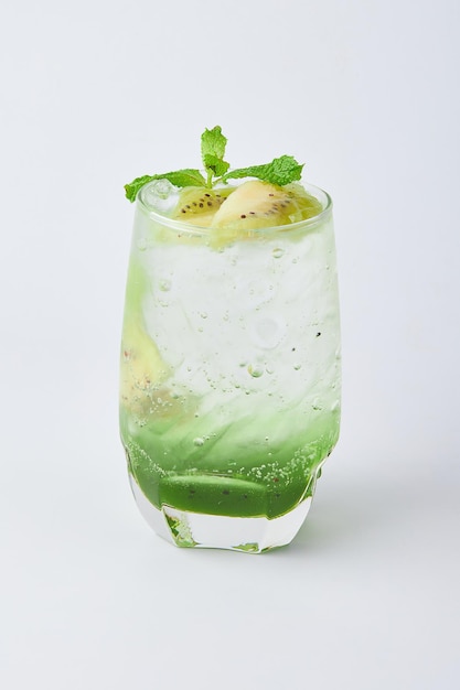 Raffreddante Kiwi Soda con ghiaccio coperto di fette di kiwi e menta isolato su sfondo bianco